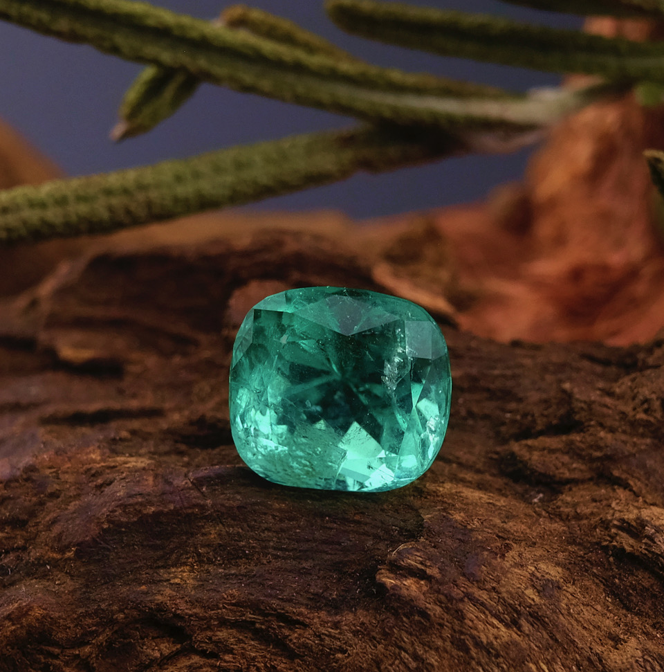 Cushion-cut Colombian emerald on wood